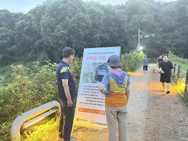 풍암호수 산책길을 걷던 시민 2명이 안내판을 읽고 있는 모습. /임지섭 기자 ljs@namdonews.com