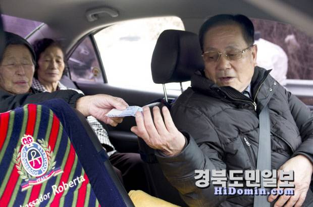 청송 행복택시 이용자가 운전기사에게 천 원의 택시비를 직접 건네고 있다. 사진=청송군 제공