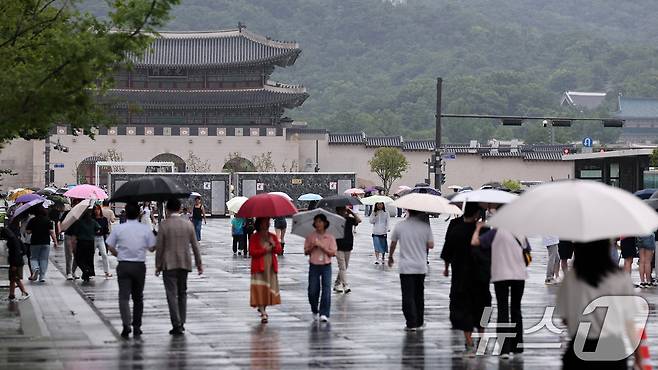 전국 대부분 지역에 비가 내린 14일 서울 종로구 광화문광장에서 시민들이 우산을 쓴 채 발걸음을 옮기고 있다. 2025.7.14/뉴스1 ⓒ News1 김성진 기자