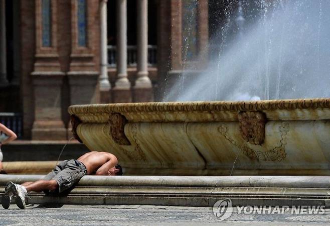스페인 남부 도시 세비야에서 한 시민이 분수대에 머리를 담그며 더위를 식히고 있다. 연합뉴스