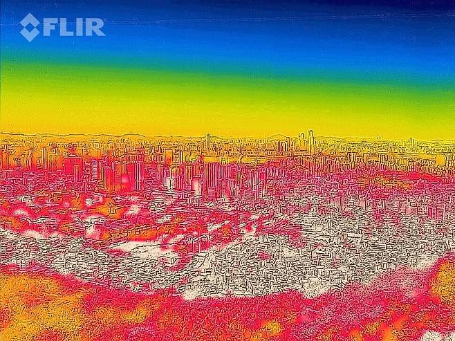 지난 11일 서울 남산에서 열화상 카메라로 촬영한 시내 모습. 사진 속 높은 온도는 붉은색으로, 낮은 온도는 푸른색으로 표시된다. 연합뉴스