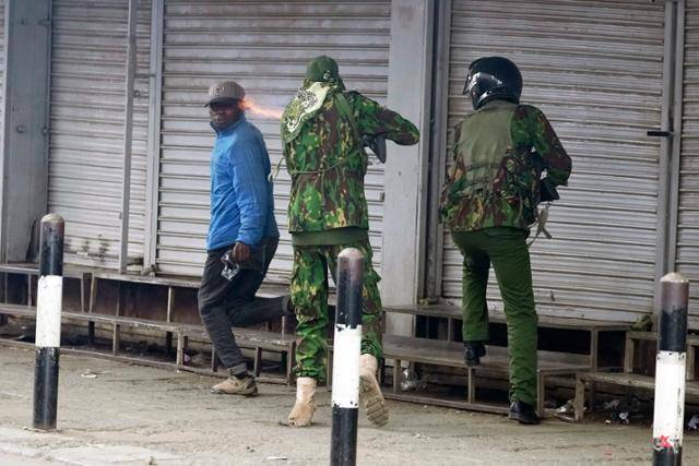 17일 케냐 나이로비에서 한 경찰관이 노점상으로 보이는 남성을 향해 총을 쏘고 있다. 케냐 경찰은 지난 수십 년간 시위나 비판을 잠재우기 위한 명분으로 폭력과 초법적인 살인을 자행했다는 비판을 받아왔다. AP=뉴시스