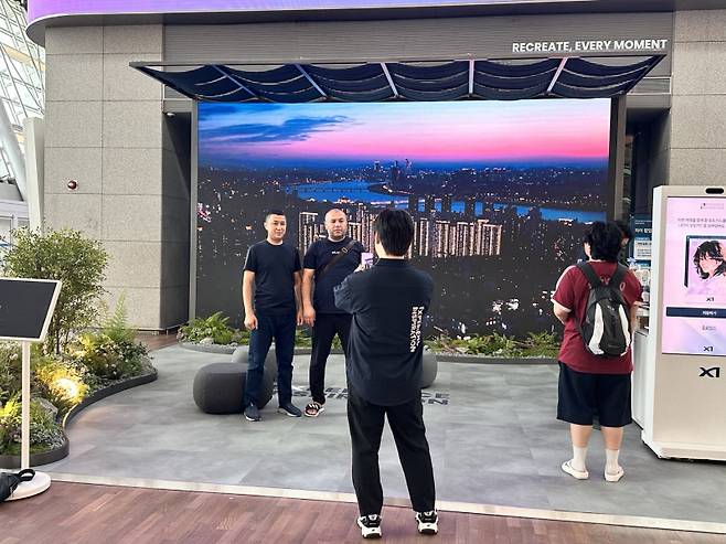 GS건설의 인천국제공항 팝업스토어를 배경으로 기념 사진을 찍는 외국인 방문객들. GS건설 제공