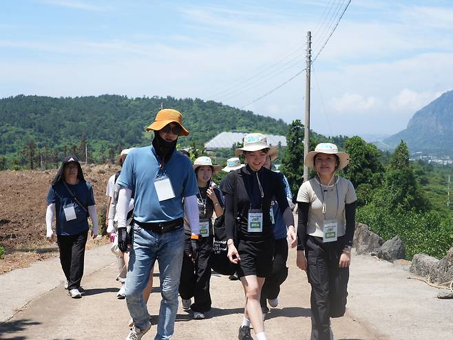 Participants of Jeju National University's learncation program for 2025 walk along the Jeju Olle Trail, a long-distance footpath on Jeju Island. [JEJU NATIONAL UNIVERSITY]