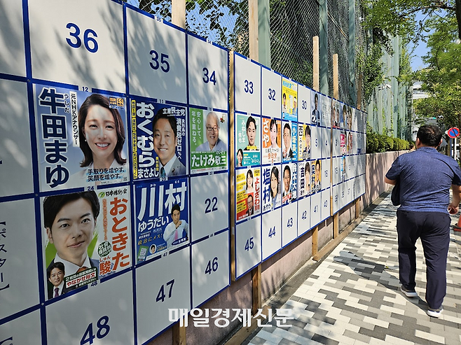 20일 일본 참의원 선거가 치러지는 가운데 한 시민이 선거 벽보 앞을 지나가고 있다. [도쿄 이승훈 특파원]