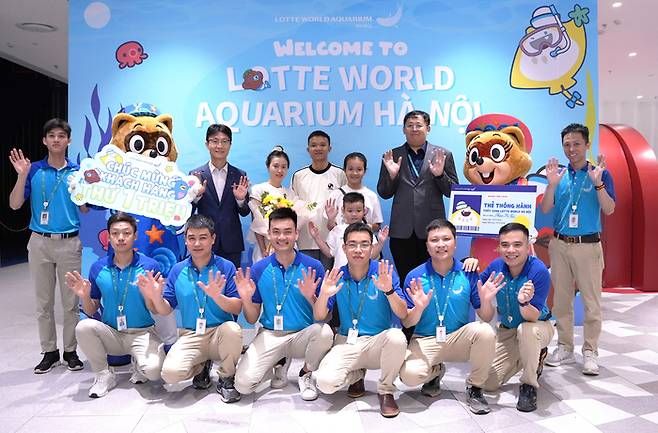 누적 관람객 100만 명 달성을 기념해 방문객과 기념 촬영 중인 이해열 롯데월드 베트남 법인장(두 번째 줄 왼쪽에서 세 번째)와 직원들 / 사진=롯데월드