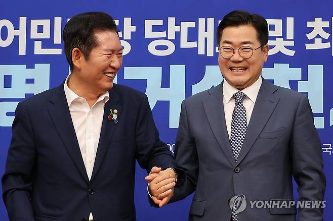 민주당 당대표 후보 '만나면 손잡는 사이' (서울=연합뉴스) 김주성 기자 = 더불어민주당 정청래·박찬대(오른쪽) 당대표 후보가 15일 서울 여의도 국회에서 열린 공명선거 실천 서약식에서 서약문에 서명한 뒤 손을 잡고서 기념촬영 하고 있다. 2025.7.15 utzza@yna.co.kr