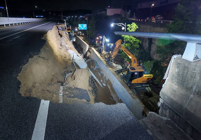 ▲ 경기도 대부분 지역에 호우주의보가 내려진 16일 오후 오산시 가장교차로 고가도로 옹벽이 무너져 소방관들이 매몰된 차량구조 작업을 하고 있다./전광현 기자 maggie@incheonilbo.com
