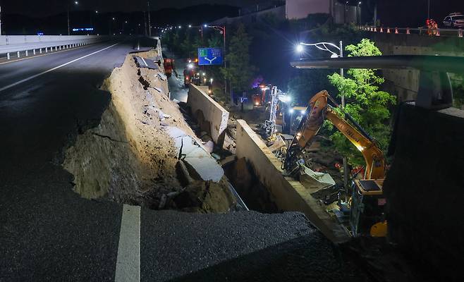 ▲ 경기도 대부분 지역에 호우주의보가 내려진 16일 오후 오산시 가장교차로 고가도로 옹벽이 무너져 소방관들이 매몰된 차량구조 작업을 하고 있다./전광현 기자 maggie@incheonilbo.com