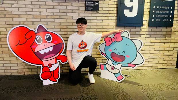 애니메이션 ‘다이노맨’ 캐릭터 모형과 포즈를 취하고 있는 김호락 감독. ㈜스튜디오버튼 제공