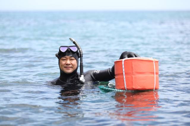 노시우 씨가 경북 울진군 북면 앞바다에서 자신이 직접 만든 테왁을 잡고 포즈를 취하고 있다. 김도훈 기자