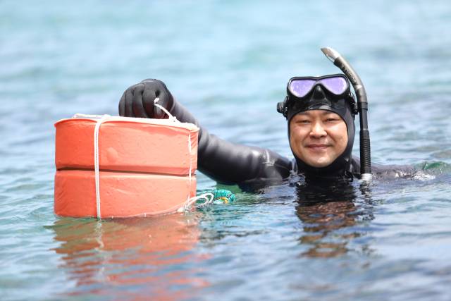노시우 씨가 경북 울진군 북면 앞바다에서 자신이 직접 만든 테왁을 잡고 포즈를 취하고 있다. 김도훈 기자
