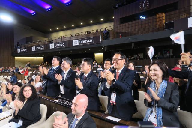 15일 프랑스 파리에서 열린 제47차 유네스코 세계유산위원회에서 차기 세계유산위원회 개최지로 대한민국이 확정되자 최응천 국가유산청장(가운데)을 비롯한 정부 대표단이 박수를 치고 있다.