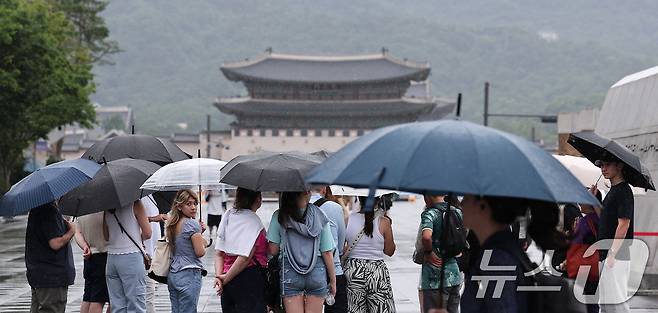 전국 대부분 지역에 비가 내린 14일 서울 종로구 광화문광장에서 시민들이 우산을 쓴 채 발걸음을 옮기고 있다. 2025.7.14/뉴스1 ⓒ News1 김성진 기자