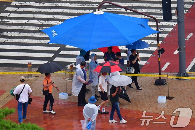 16일 오후 경북 포항시 전역에 비가 내리는 가운데 포항시청 횡단보도 앞에 설치된 대형 우산 그늘막 밑에서 시민들이 비를 피하고 있다. 2025.7.16/뉴스1 ⓒ News1 최창호 기자