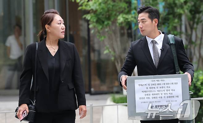 '명태균 게이트'를 최초 폭로한 전 미래한국연구소 부소장 강혜경 씨가 16일 오전 서울 종로구 KT광화문빌딩에 마련된 김건희 특검 사무실에서 '명태균 PC 및 여론조사 자료' 등 임의 제출 자료를 든 문건일 변호사와 함께 참고인 조사를 받기 위해 출석하고 있다. 2025.7.16/뉴스1 ⓒ News1 오대일 기자