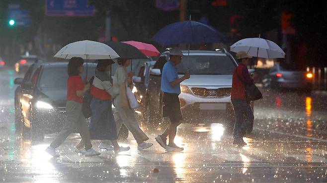 서울 전역에 호우주의보가 발효된 16일 서울 노원구 상계동 거리에서 시민들이 내리는 비를 맞으며 횡단보도를 건너고 있다. 뉴시스