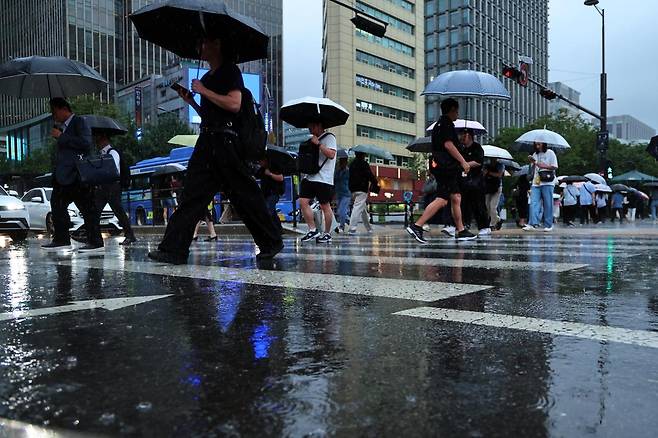 비가 내린 16일 오후 서울 종로구 광화문광장에서 우산을 쓴 시민들이 퇴근길 발걸음을 재촉하고 있다. 뉴스1
