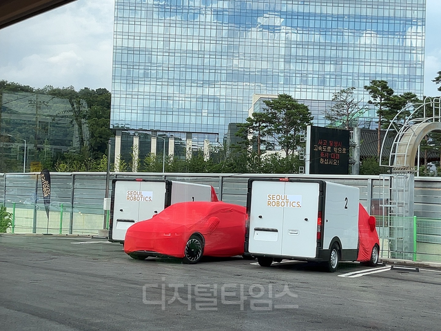 서울로보틱스가 15일 경기 판교에서 국내 미디어를 대상으로 B2B(기업간 거래) 소프트웨어 기술 ‘레벨5 컨트롤 타워’ 기술 시연에서 아이오닉 5가 2대의 물류 트럭 사이에 무인으로 주차를 하고 있다. 장우진 기자