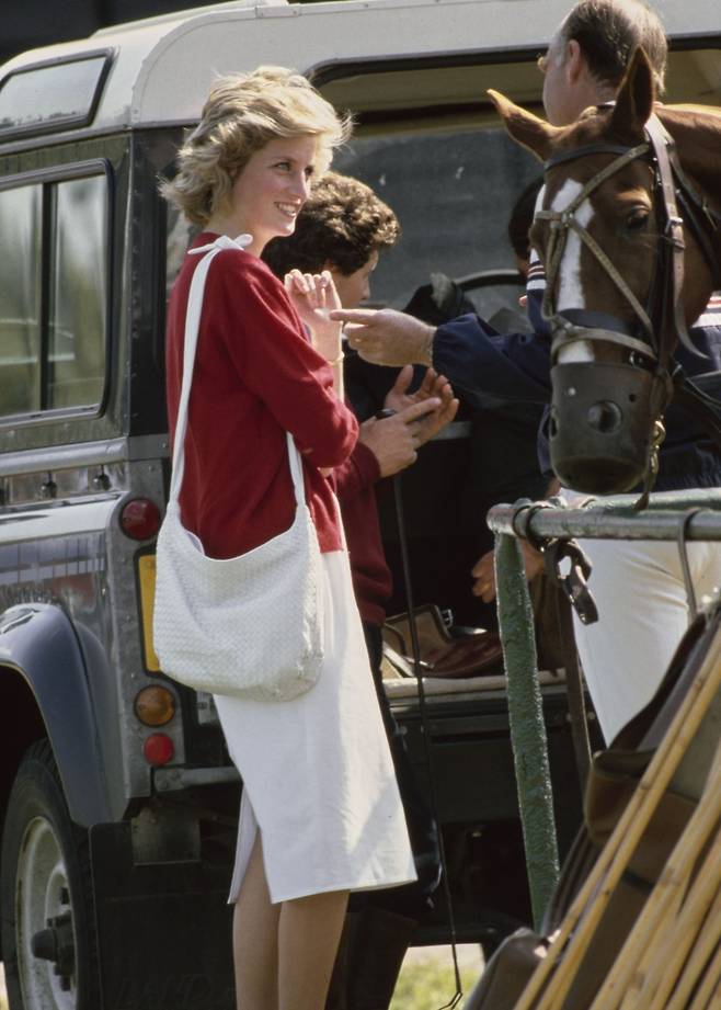 1985년 레드 컬러 카디건에 화이트 컬러 인트레치아토 백을 매치한 고(故) 다이애나 왕세자비.