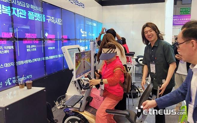 부산테크노파크 부스에서 관람객이 디지털 복지관 플랫폼 구축사업을 통해 제작된 스마트 기기를 체험하고 있다.