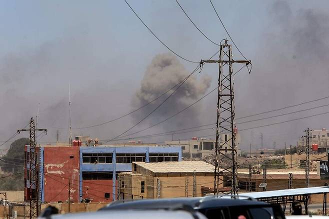 시리아 남부 스웨이다에서 베두인족과 드루즈족이 충돌이 100명 가까이 숨진 가운데, 15일(현지시각) 스웨이다 인근 도시에서 이스라엘군의 공습으로 검은 연기가 피어오르고 있다. 스웨이다/AFP 연합뉴스