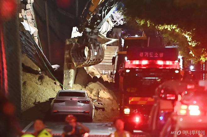 [오산=뉴시스] 김종택 기자 = 수도권 등 중부지역에 호우주의보가 발효된 16일 오후 경기 오산시 가장교차로 고가도로 옹벽이 무너져 소방관들이 매몰된 차량을 구조작업하고 있다. 2025.07.16. /사진=뉴시스