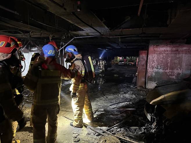 17일 오후 광명시 소하동의 한 10층짜리 아파트 1층 필로티 주차장에서 화재가 발생한 가운데 소방대원들이 화재 현장을 살펴보고 있다. 사진=경기도소방재난본부