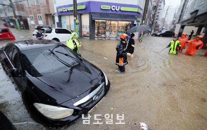 극한 호우에 물에 잠긴 도심호우경보가 발효된 17일 광주광역시 북구 용봉동 한 도로가 물에 잠겨 차량이 침수된 가운데 현장에 출동한 소방대원들이 배수작업 등 구조활동을 하고 있다. /임문철 기자 35mm@namdonews.com