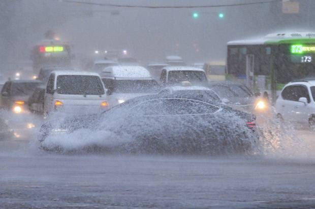 17일 오전 광주 남구 백운광장 일대가 갑자기 내린 폭우로 도로 곳곳이 침수된 가운데 한 차량이 고인 물을 빠르게 지나며 큰 물보라를 일으키고 있다. /김진수 기자 jeans@kwangju.co.kr