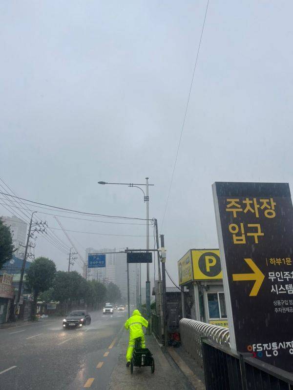 광주 양동시장 인근 도로에서 방수복을 입은 배달노동자가 리어카를 끌며 빗속을 지나고 있다. 송보현 기자