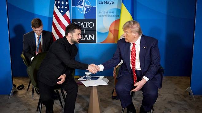 지난 2월 백악관 회담 당시 양복 정장 대신 티셔츠 차림으로 도널드 트럼프 미 대통령과 만나 서로 고함을 지르는 등 격렬한 말다툼을 벌였던 볼로디미르 젤렌스키 우크라이나 대통령이 25일 네덜란드 헤이그에서 열린 북대서양조약기구(나토) 정상회의에서 트럼프와 만난 2번째 회담에서는 티셔츠 대신 양복을 착용했다고 뉴욕 포스트가 26일 보도했다. 25일 트럼프 대통령과 회담하는 젤렌스키 대통령. 2025.06.26. 사진 출처 : 키이우 포스트. 뉴시스