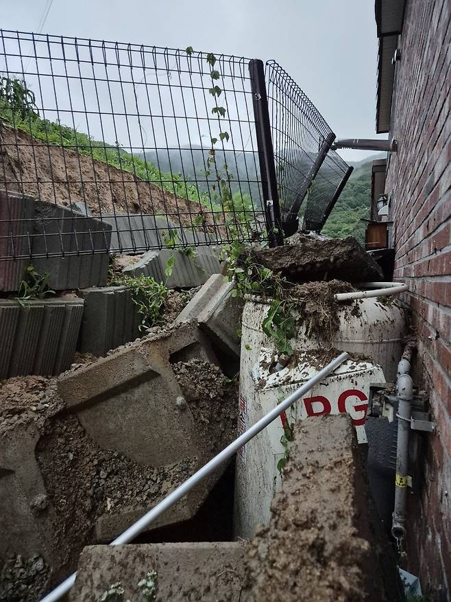 17일 오전 5시56분께 충북 음성군 음성읍의 한 주택 뒷마당에서 빗물에 무너진 옹벽이 200㎏짜리 LPG통을 덮쳤다. 가스가 소량 누출됐으나 긴급 안전조치로 추가 피해는 발생하지 않았다. 2025.07.17. 충북소방본부 제공