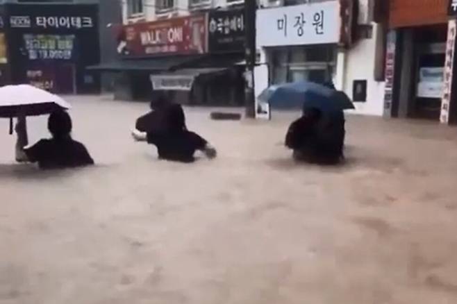 광주 전역에 폭우가 쏟아진 17일 오후 광주 북구 용봉동 거리에서 시민과 학생이 가슴 높이까지 차오른 흙탕물을 헤치며 귀가하고 있다. 독자 제공.