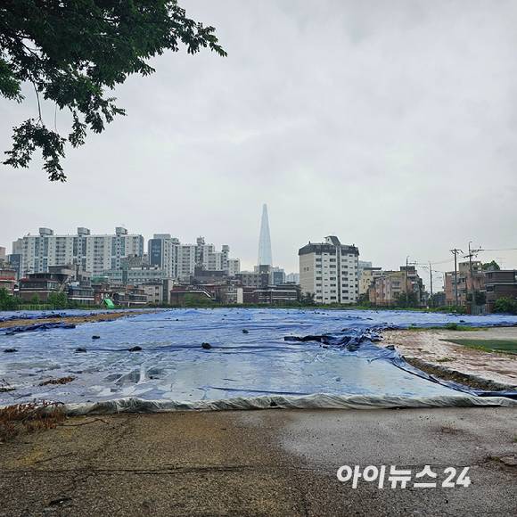 서울 송파구 풍납동의 '창의마을 풍납캠프' 부지에 가까이 가보니 시설물이 철거된 자리에 큰 천이 뒤덮인 채 방치돼 있다. 2025.07.16 [사진=이효정 기자 ]