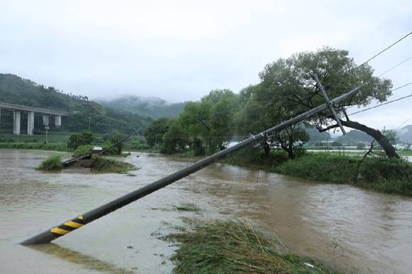 호우특보가 내려진 충남 공주시 사곡면에서 한 도로가 무너져 내렸고 전봇대가 위태롭게 쓰러져 있다. 2025.7.17 [사진=연합뉴스]