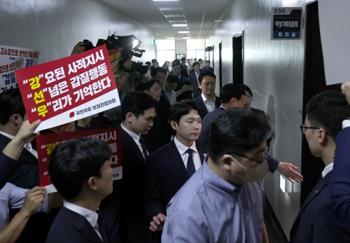 국민의힘 보좌진협의회 소속 보좌관들이 피켓시위를 벌이자 강선우 여성가족부 장관 후보자가 보좌관들의 호위를 받으며 지난 14일 서울 여의도 국회 여성가족위원회에서 열린 인사청문회에 입장하고 있다. [사진 출처 = 공동취재단]