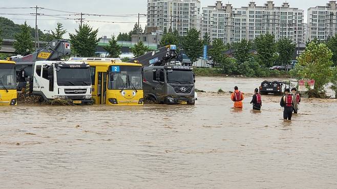 밤사이 쏟아진 집중폭우로 침수 피해가 발생한 17일 충남 아산시 배방읍 곡교천변에서 소방대원들이 불어난 빗물에 쓰러진 시설물과 침수차량을 살펴보고 있다. /사진=뉴스1.