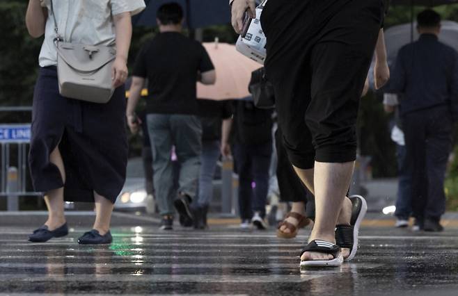 서울지역에 강한 비가 내리는 가운데 17일 서울 종로구 세종대로에서 한 시민이 슬리퍼를 신고 출근길에 나서고 있다. /사진=뉴시스