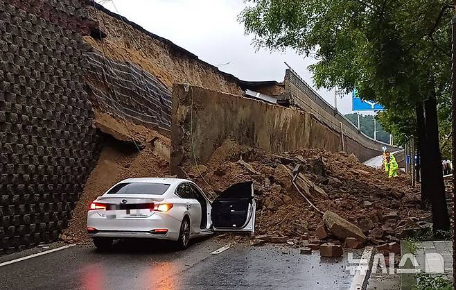 [오산=뉴시스] 김종택 기자 = 수도권 등 중부지역에 호우주의보가 발효된 16일 경기 오산시 가장교차로 옹벽이 도로로 무너져 차량을 덮치는 사고가 발생해 소방 당국이 대응 1단계를 발령, 구조작업을 벌이고 있다. (사진=경기도소방재난본부 제공) 2025.07.16. photo@newsis.com