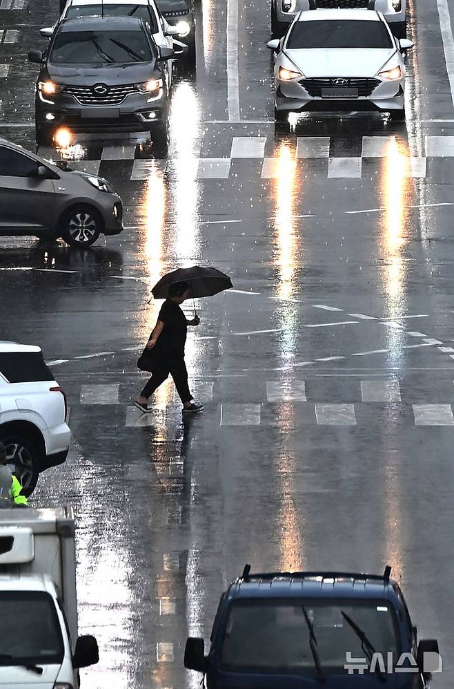 [수원=뉴시스] 김종택 기자 = 수도권 등 중부지역에 호우주의보가 발효된 16일 경기 수원시 팔달구 경수대로에서 한 시민이 우산을 쓰고 이동하고 있다. 2025.07.16. jtk@newsis.com