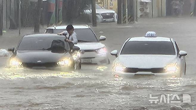 [광주=뉴시스] 이영주 기자 = 광주지역에 시간당 86㎜ 폭우가 쏟아진 17일 오후 광주 북구청 앞 교차로에서 차량들이 폭우로 넘치는 빗물에 갇혀 오가지 못하고 있다. 2025.07.17. leeyj2578@newsis.com