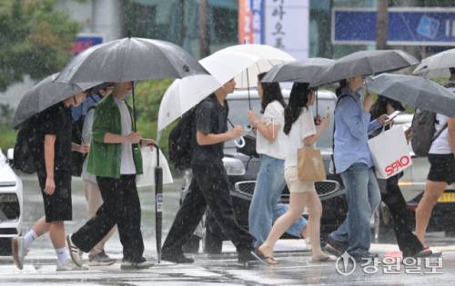 도 전역에 많은 양의 장맛비가 내린 17일 춘천시 명동거리에서 우산을 쓴 시민들이 장대비를 뚫고 길을 건너고 있다. 박승선기자