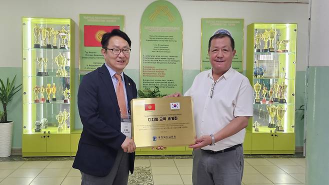 충북교육청의 디지털 인프라 지원 1호 학교로 지정된 21번학교에 현판을 전달하고 있다