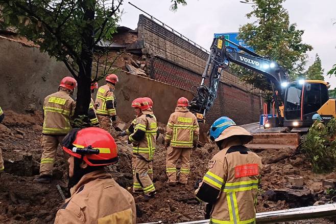16일 오후 7시 4분께 경기 오산시 가장교차로 고가도로의 10m 높이 옹벽이 도로로 무너지며 차량 2대를 덮치는 사고가 발생해 소방대원들이 구조작업을 하고 있다. (사진=연합뉴스)