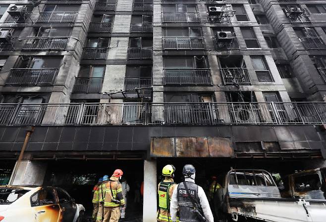 전날 주차장에서 발생한 화재로 다수의 인명피해가 발생한 경기도 광명시 소하동 한 아파트에서 18일 경찰과 소방 등 관계자들이 현장을 살펴보고 있다. (사진=연합뉴스)
