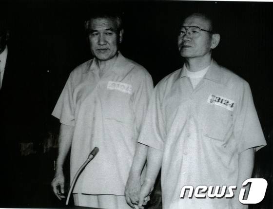 1996년 8월 26일 서울중앙지법 417호 대법정에서 열린 1심 선고 공판에 출석한 전두환(오른쪽), 노태우 전 대통령이 법정에서 서로 손을 잡고 선고를 기다리고 있다. ⓒ News1