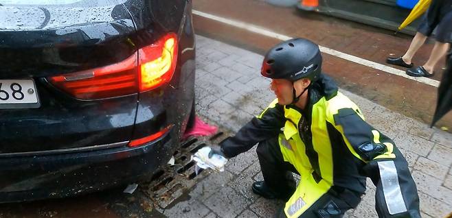 지난 17일 낮 12시 30분쯤 광주광역시 북구 중흥동 전남대 정문 도로에서 침수차량 배수작업하던 박선홍 소방위가 유실된 현금봉투를 발견한 모습./광주 북부소방서
