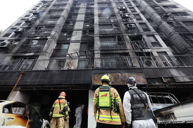 주차장에서 발생한 화재로 다수의 인명피해가 발생한 경기도 광명시 소하동 한 아파트에서 18일 경찰과 소방 등 관계자들이 현장을 살펴보고 있다. /연합뉴스