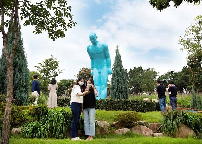 대구 서구 이현공원의 조각상 ‘그리팅맨’ 앞에서 방문객들이 기념사진을 찍고 있다. 대구 서구 제공